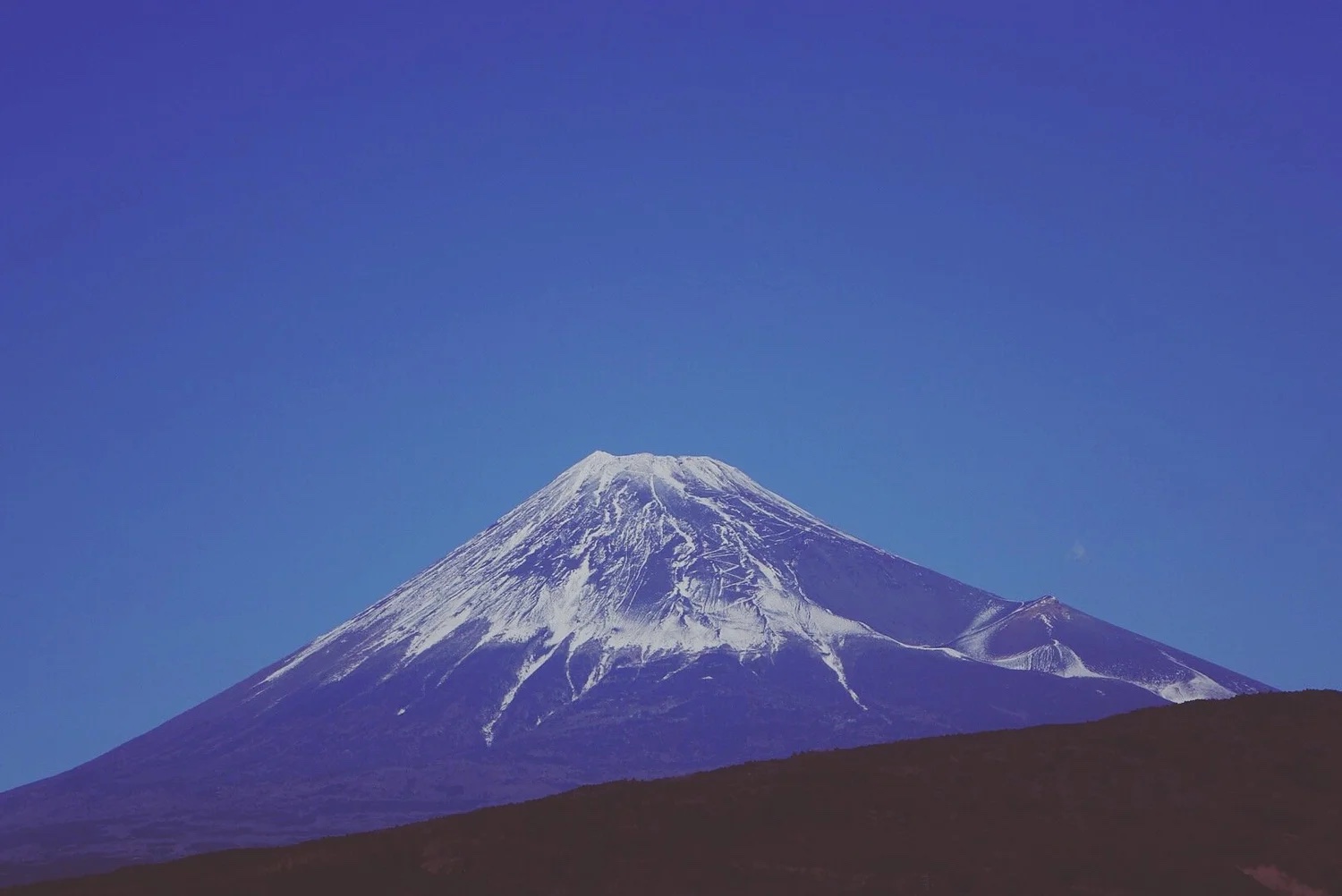 Snow-capped Mt. Fuji under a clear sky.