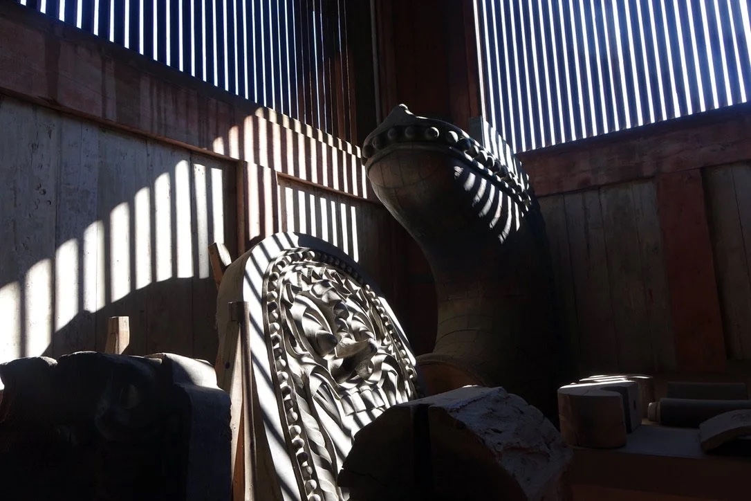 Statue silhouetted by window light.