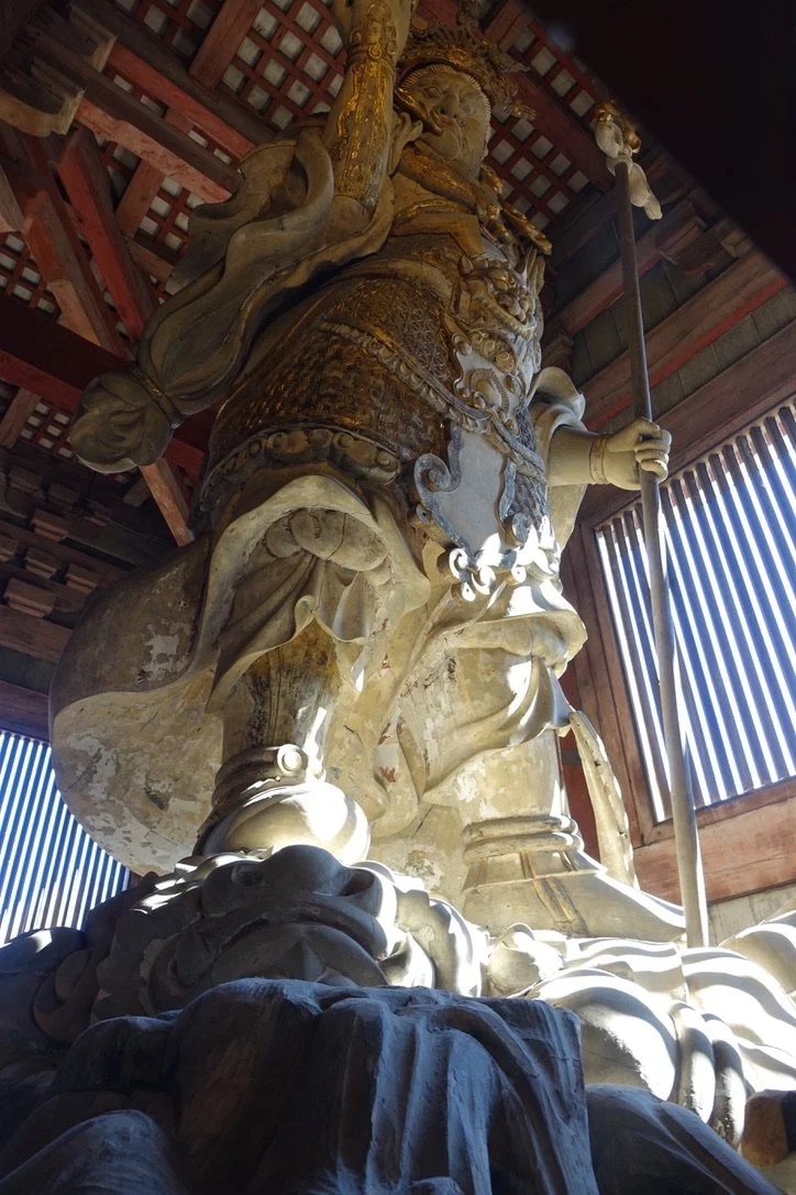 A guardian king statue with spear.