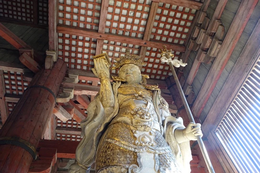 Gilded guardian statue under the hall roof.