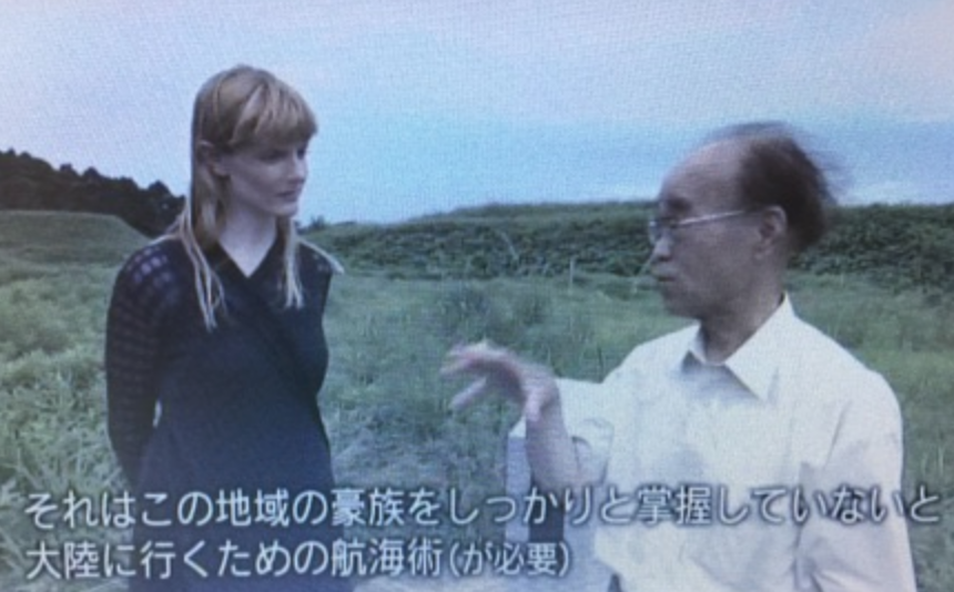 Lindsey in conversation during filming of the FBS documentary, standing in a coastal field.