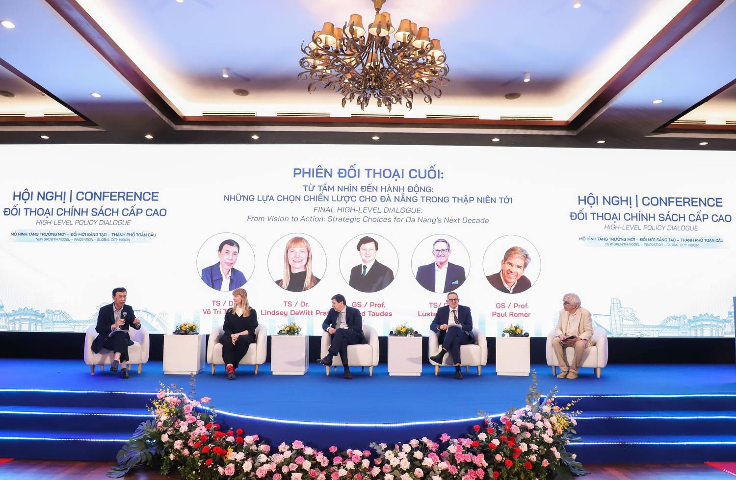 Wide view of the closing high-level dialogue stage in Da Nang: six panelists in white armchairs beneath a screen reading From Vision to Action, Lindsey second from left.