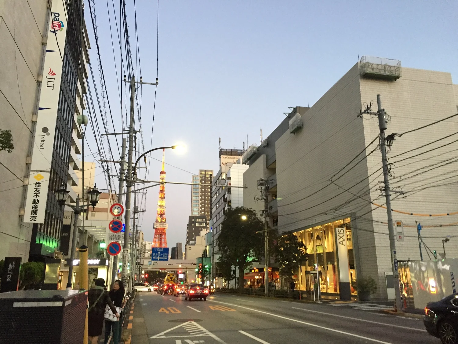 Tokyo street at dusk, Tokyo Tower lit orange in the distance.