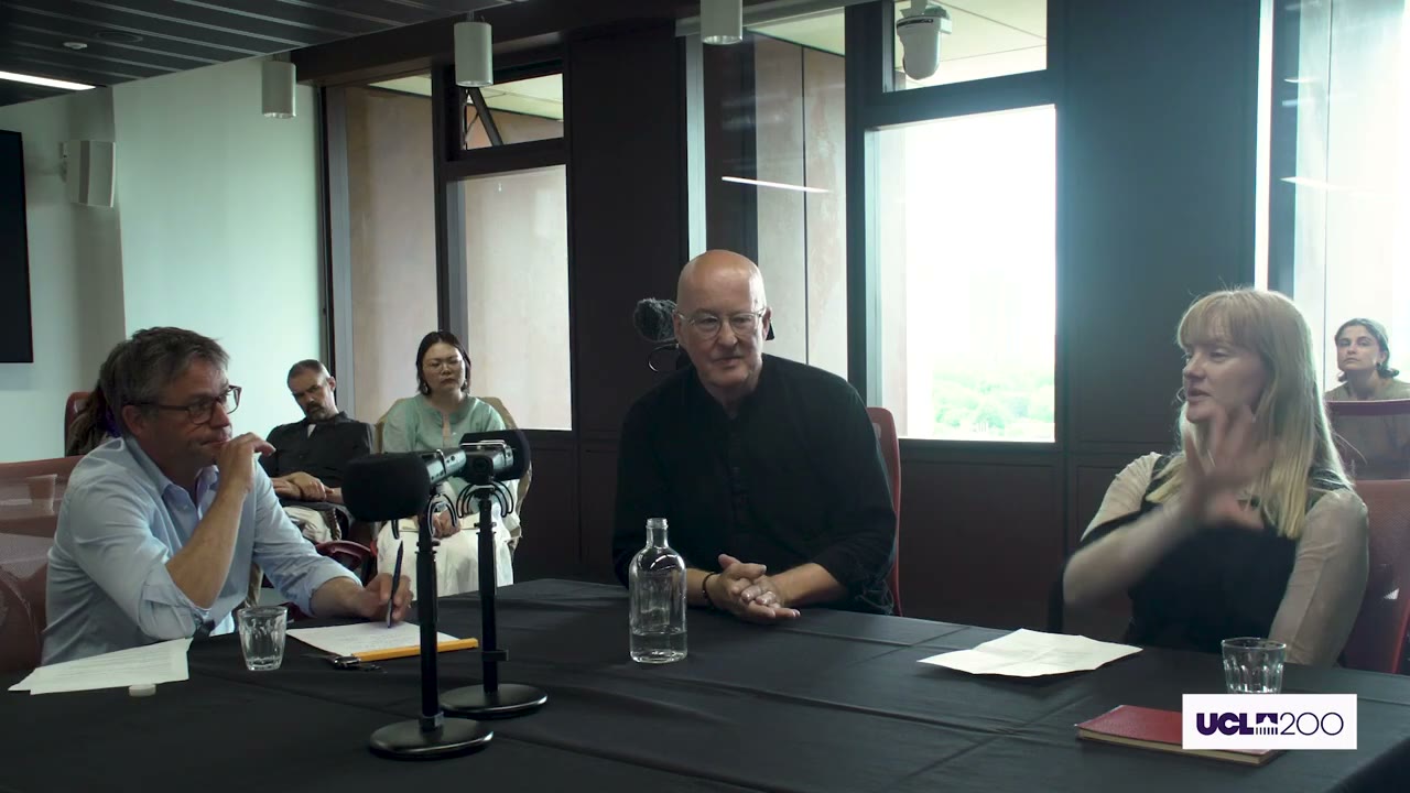 Lindsey speaking at a roundtable table beside two other panelists.